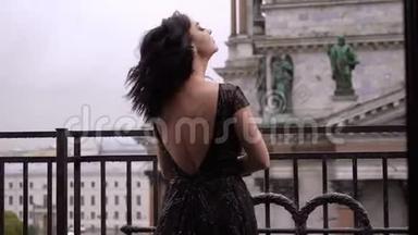 年轻的黑发女人，穿着黑色<strong>豪</strong>华<strong>礼</strong>服，住在城市的阳台上